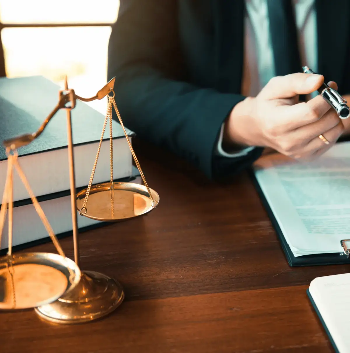 Balance de la justice dorée posée sur des livres de droit, avocat en arrière-plan