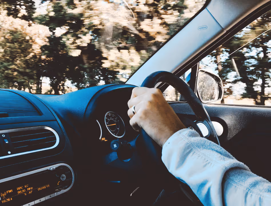 Conducteur tenant le volant d'une voiture en circulation