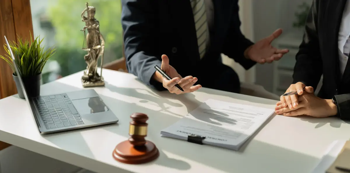 Avocate en entretien avec un client, statuette de la Justice sur le bureau