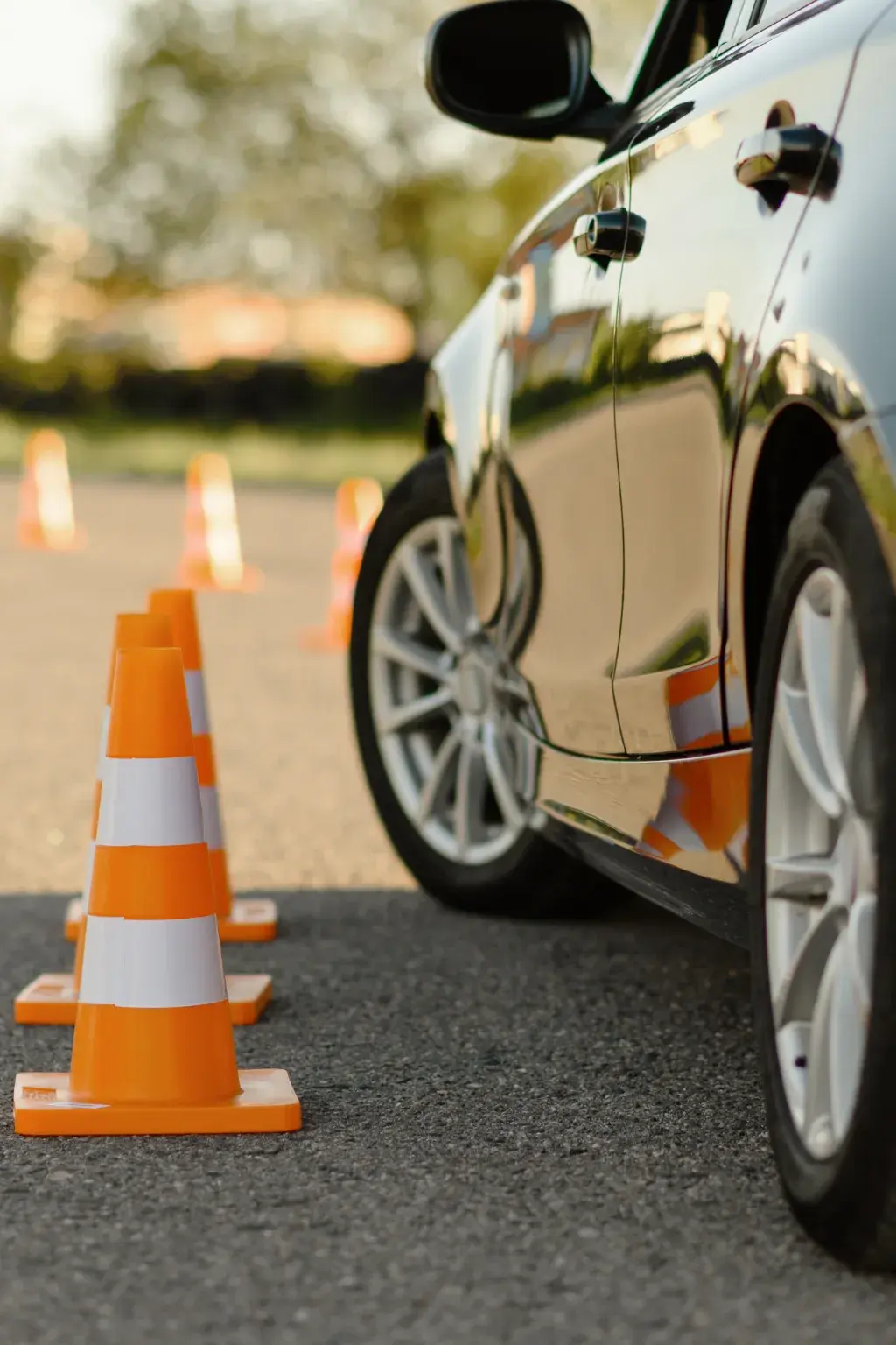 Cônes de signalisation orange posés près d'une voiture garée sur le bitume