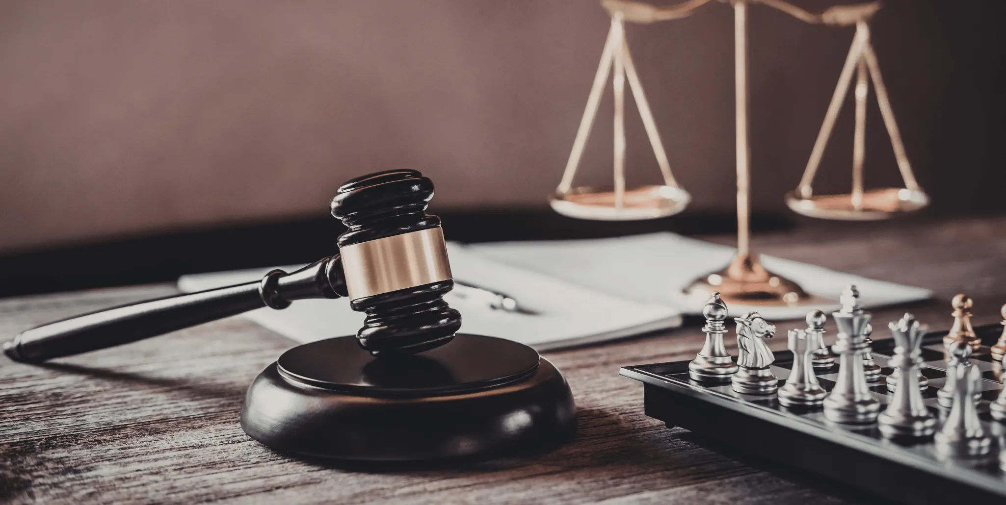 Marteau de juge posé devant une balance de la justice et un jeu d'échecs