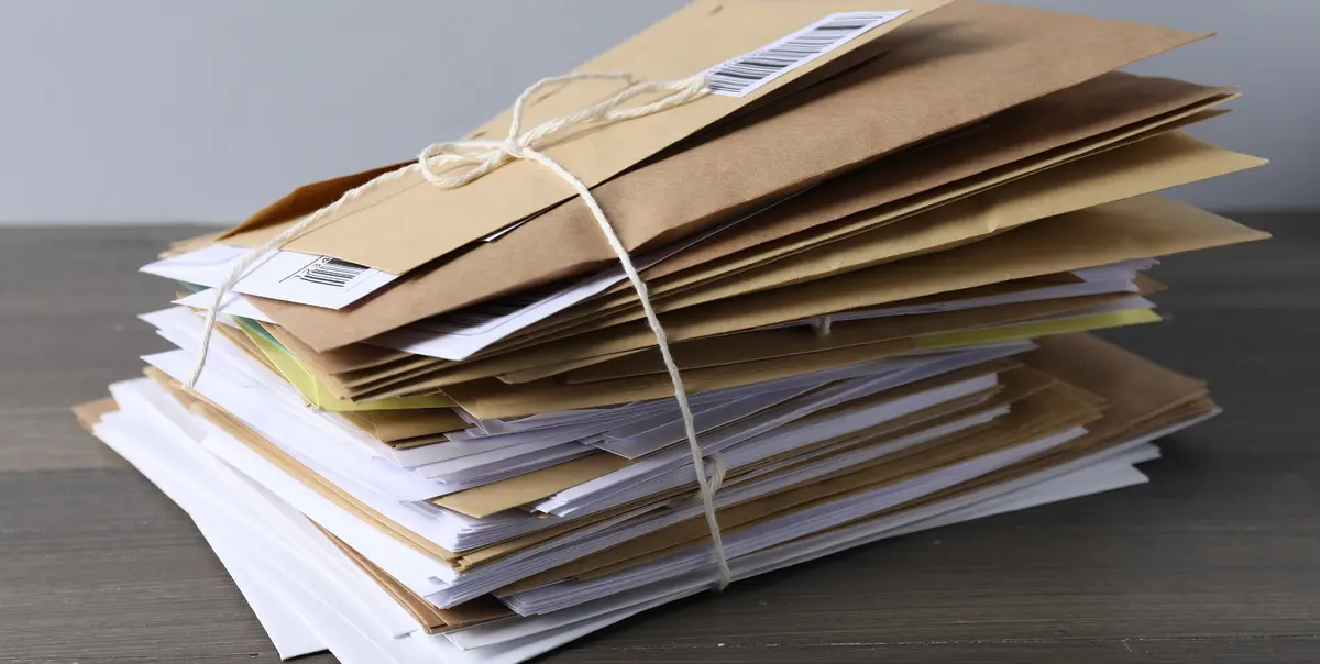 Pile de lettres et d'enveloppes en attente, liée par une ficelle
