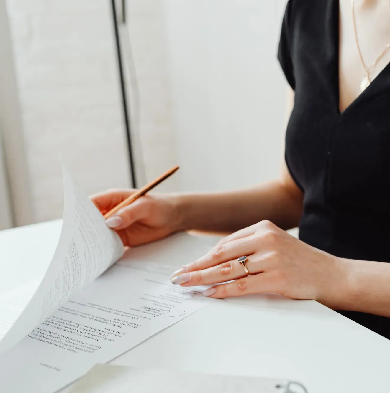 Main tenant un stylo au-dessus d'un contrat à signer