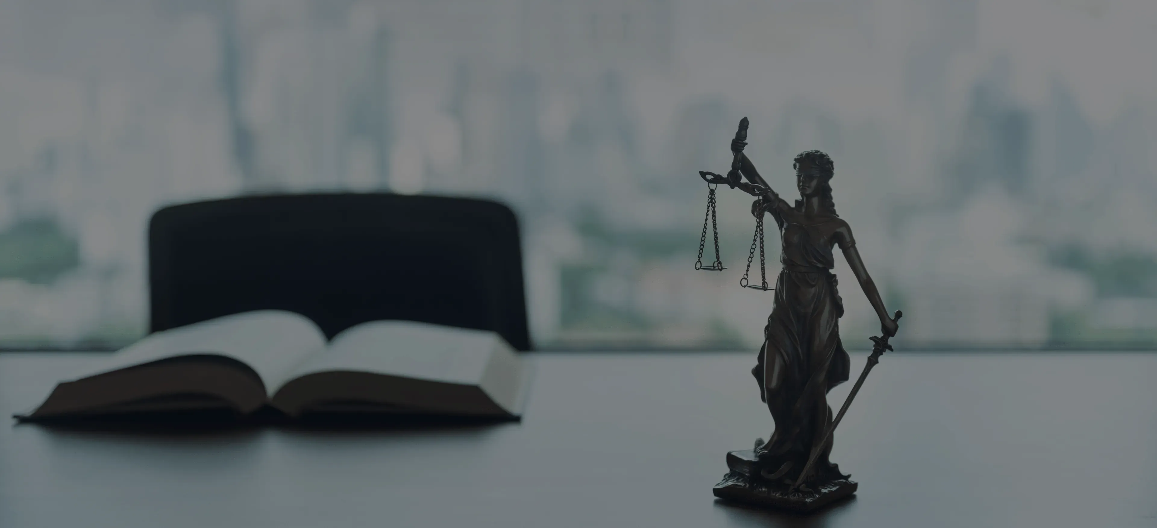 Statuette de la Justice tenant une balance, à côté d'un code juridique ouvert, vue sur Paris en arrière-plan