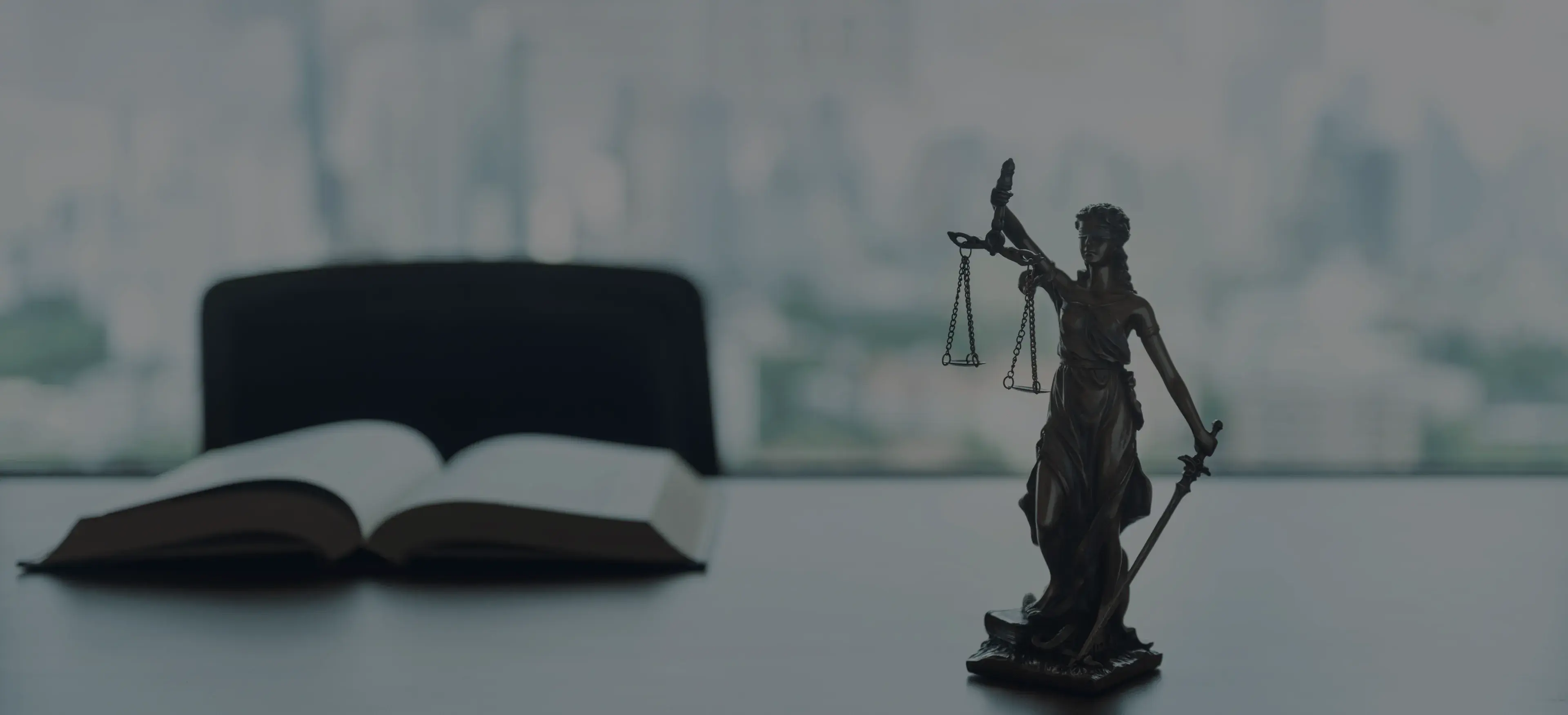 Statuette de la Justice tenant une balance, à côté d'un code juridique ouvert, vue sur Paris en arrière-plan